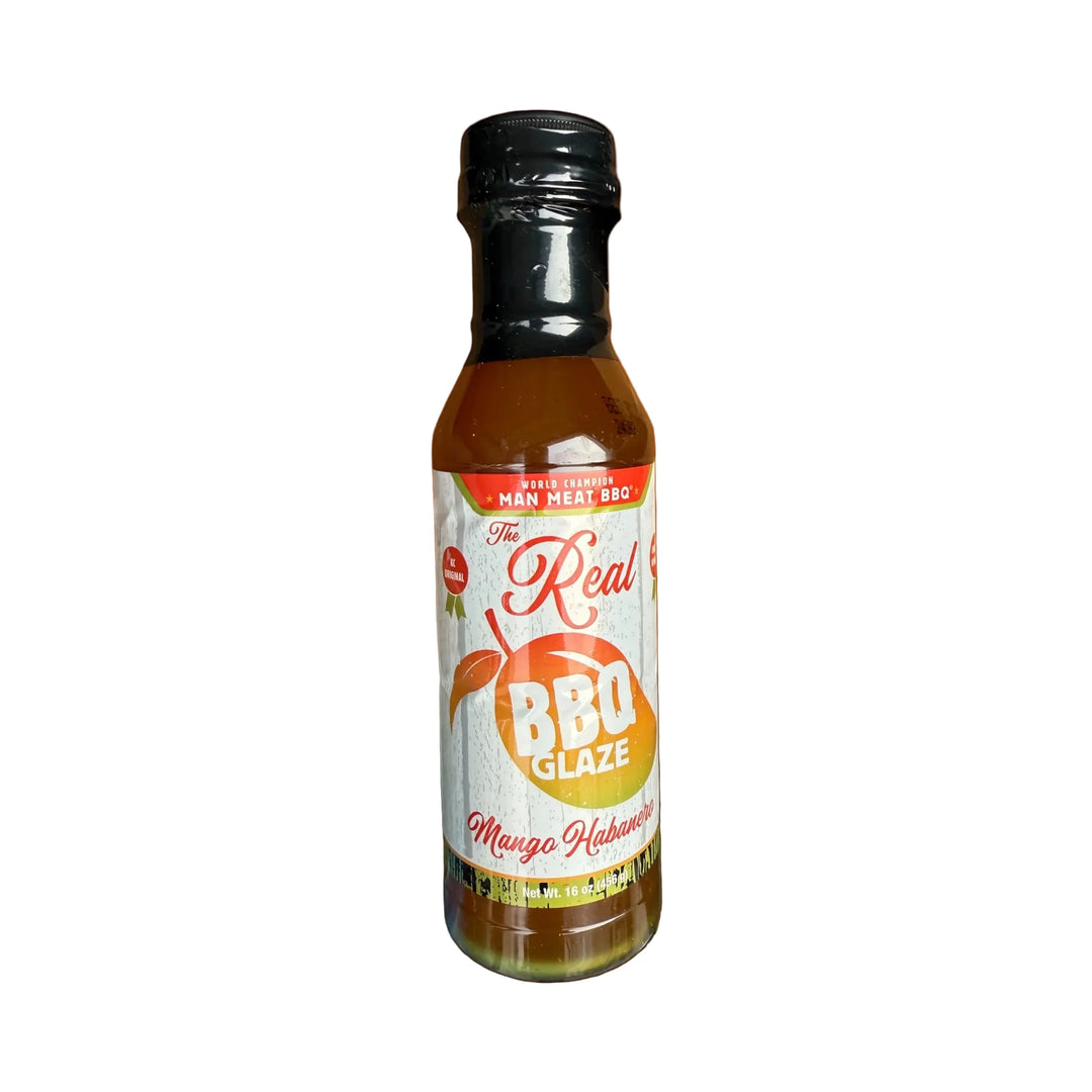 Bottle of 'The Real BBQ Glaze' on a wooden surface with an orange background